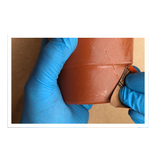 Reparación de una pieza con resina poliéster y lija, usando guantes